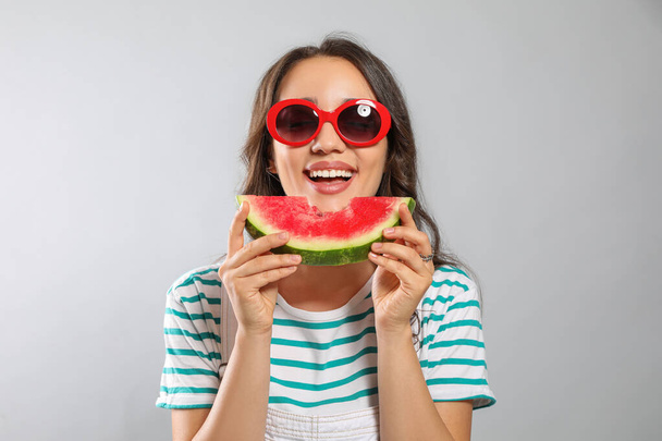 Beautiful young woman with watermelon on grey background - Fotografie, Obrázek