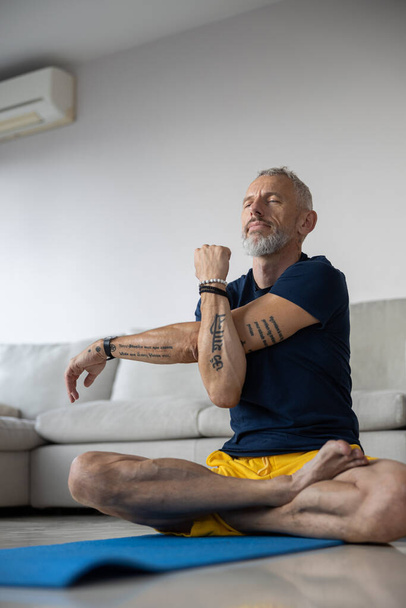 Male with tattoos is stretching his hand - 写真・画像