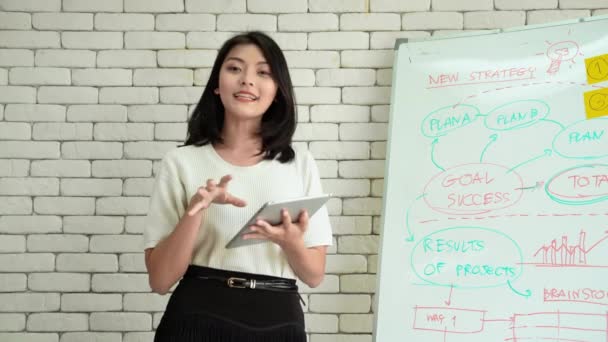 Mooie Aziatische vrouwen presenteren hun zakelijke informatie online op een whiteboard. - Video