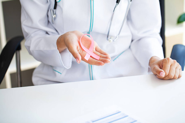 Рожева стрічка для обізнаності про рак молочної залози у лікаря
 - Фото, зображення