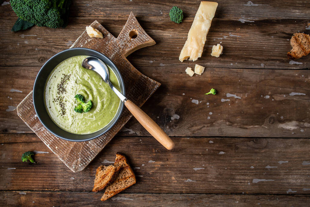 Vegetarian vegan broccoli cream soup with parmesan and crispy croutons. Top view. copy space. Healthy eating. - Fotó, kép