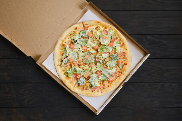 Pizza with fried chicken meat, lettuce and tomato in cardboard package - Foto, immagini