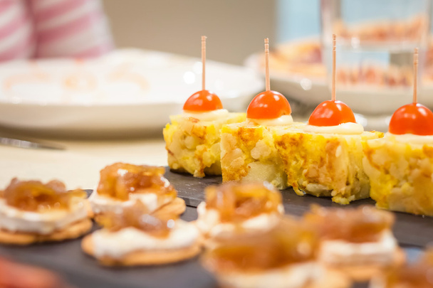 Tapas de tortilla española y queso con pinchos de cebolla
 - Foto, imagen