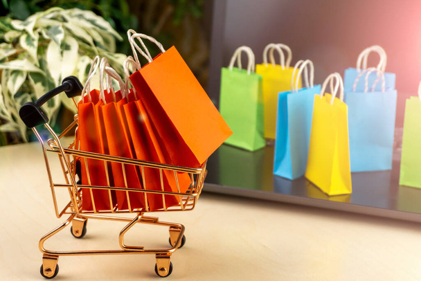 Online-Shopping-Konzept. Kleine Lieferboxen, Smartphones, Einkaufstaschen, Einkaufskörbe stehen auf dem Laptop. Kopierraum - Foto, Bild