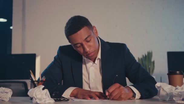 boze Afro-Amerikaanse zakenman schrijft en verkruimelt papier in het kantoor - Video