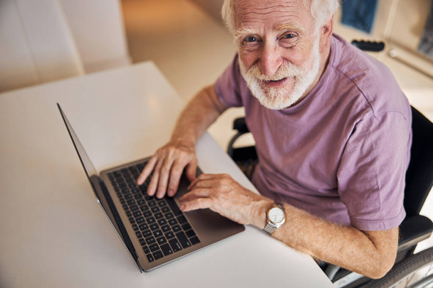 Contented modern pensioner posing with his gadget - Φωτογραφία, εικόνα