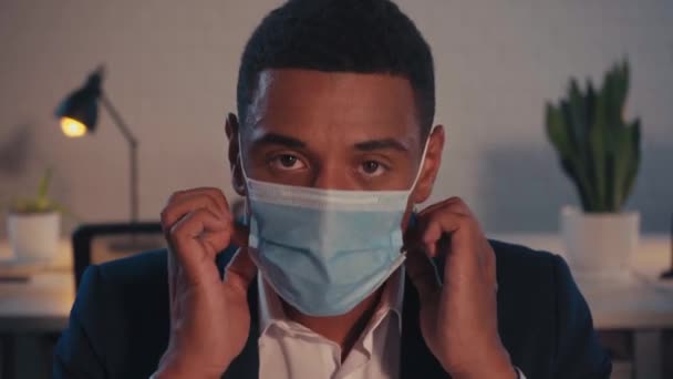 african american businessman taking off medical mask in office - Záběry, video
