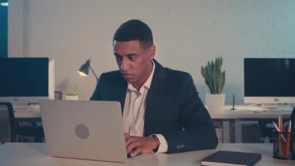 jeune homme d'affaires afro-américain tapant sur ordinateur portable la nuit au bureau - Séquence, vidéo