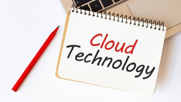 Laptop, red pen and notepad with text CLOUD TECHNOLOGY in the white background - Foto, Bild