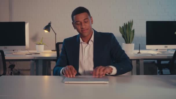 Afrikaans Amerikaans zakenman verhuizen laptop en het eten van pizza in het kantoor - Video
