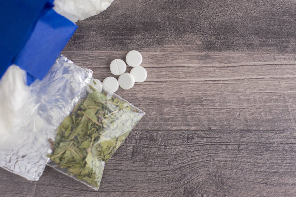 almacenamiento de sustancias prohibidas: una variedad de drogas: heroína, cocaína, hierba y tabletas sospechosas colocadas en una mesa a la izquierda - Foto, imagen