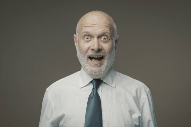 Cheerful surprised businessman looking at camera, successful business concept - Фото, изображение