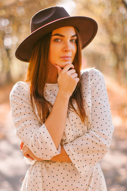 Girl walks in a dress and hat in the park. - 写真・画像