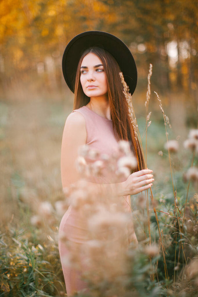 Girl walks in a dress and hat in the park. - Fotoğraf, Görsel