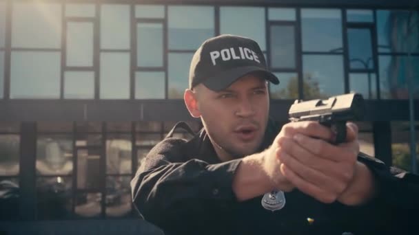 Policjant trzymający broń i rozmawiający na ulicy miejskiej  - Materiał filmowy, wideo