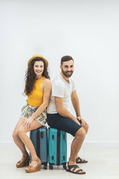 Nice couple sitting on suitcase looking delighted. - Foto, immagini