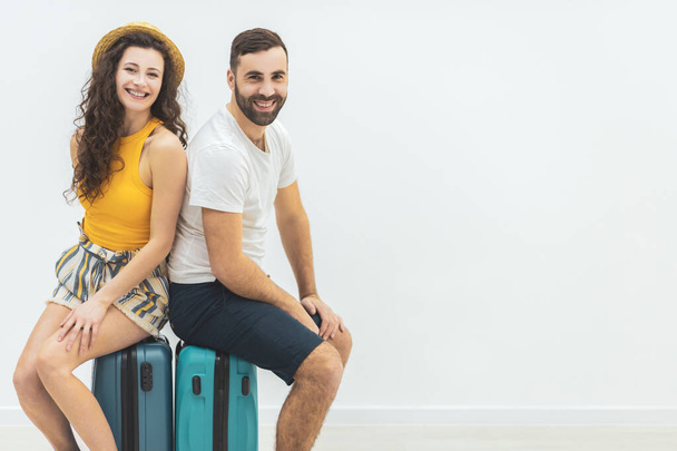 Nice couple sitting on suitcase looking delighted. - Photo, Image