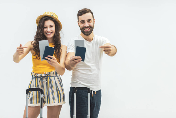 Happy young couple of tourists smiling and holding passports. - Foto, Imagen