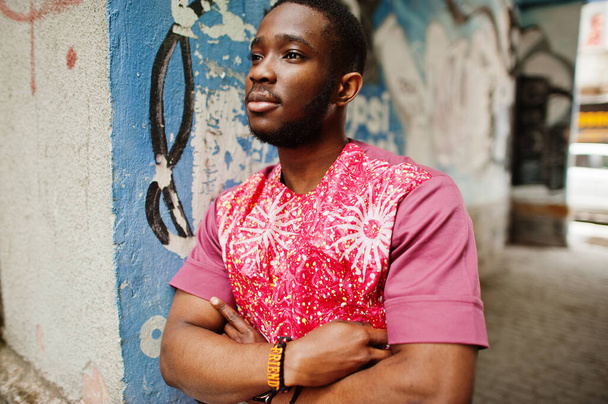 Portrait of a black young man wearing african traditional red colorful clothes. - Photo, Image