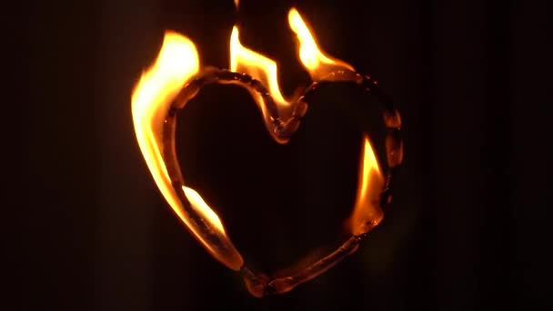炎の心。炎に輝くハート型。ビデオは夜遅くに撮影されました - 映像、動画