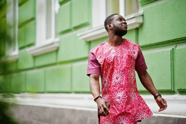 Portrait of a black young man wearing african traditional red colorful clothes. - Foto, Bild