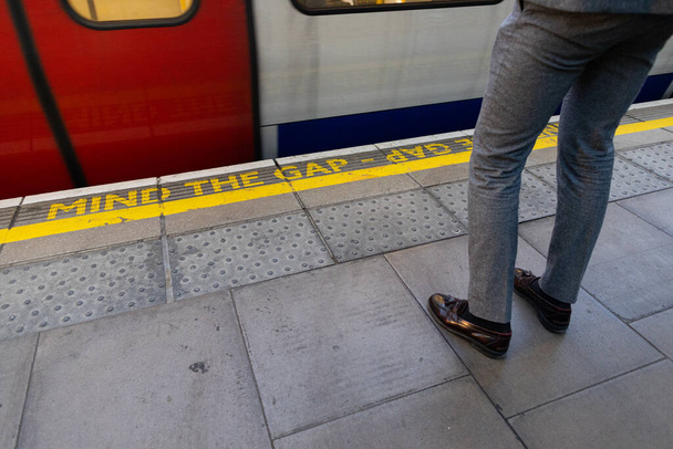 Ο άνθρωπος περιμένει το τρένο στο σταθμό του Λονδίνου - Φωτογραφία, εικόνα
