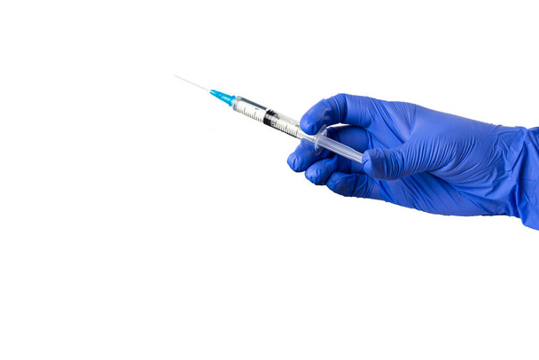 Nurse's gloved hand holds medical syringe. Viral infection vaccination concept: coronavirus or flu. Isolate on white background, copy space for text - Фото, изображение