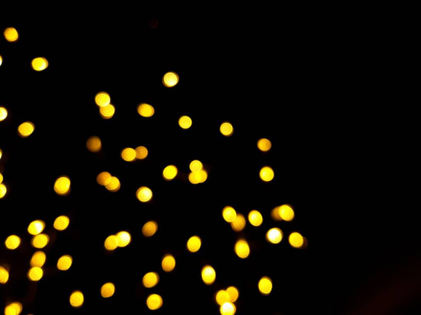 The golden sides or boke on a black background. Merry Christmas and happy New Year. Christmas background. - Foto, afbeelding