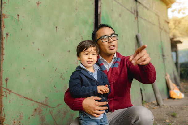 Портрет батька і сина. тато тримає маленького хлопчика, який вказує щось пальцем. єдність, освіта, дитинство, час сім'ї, батьківство.. - Фото, зображення