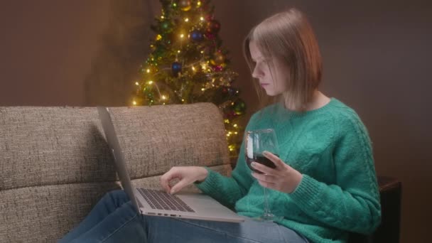 Karácsony este, nő dolgozik notebook, egyedül otthon egy pohár bort karantén idő. - Felvétel, videó