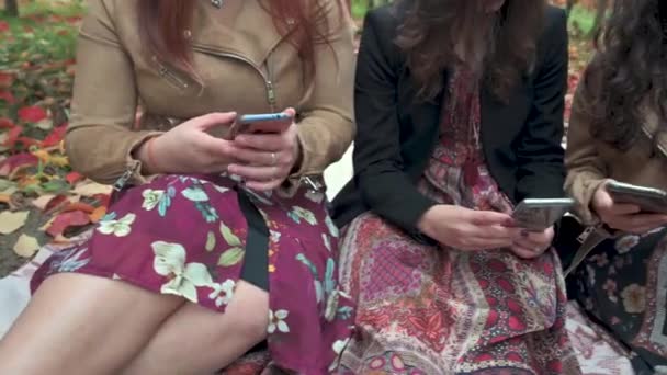 Zamknij trzy kobiece ręce trzymające i używające smartfonów. Technologia, uzależnienie, koncepcja sieci społecznościowych. - Materiał filmowy, wideo