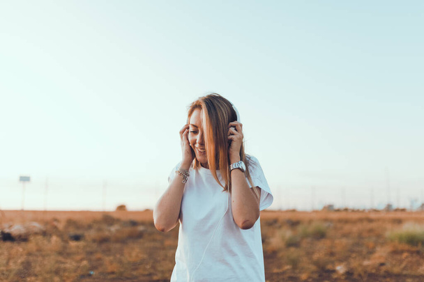 Mujer joven con su portátil escuchó comunicaciones externas con auriculares - Foto, Imagen