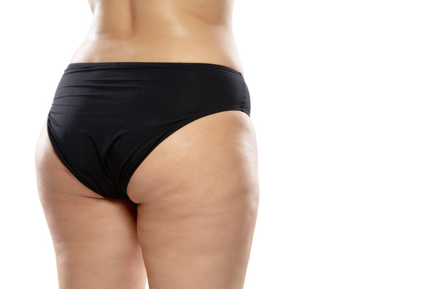 Overweight woman with fat cellulite legs and buttocks, obesity female body in black underwear isolated on white background - Foto, afbeelding