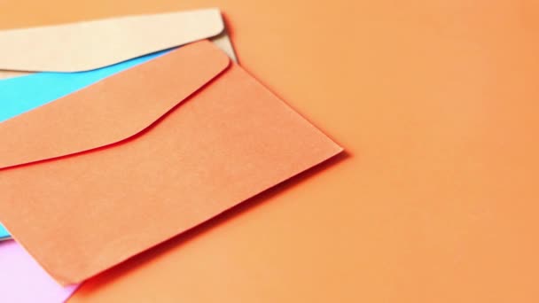 farbenfroher Umschlag auf orangefarbenem Hintergrund in Nahaufnahme . - Filmmaterial, Video