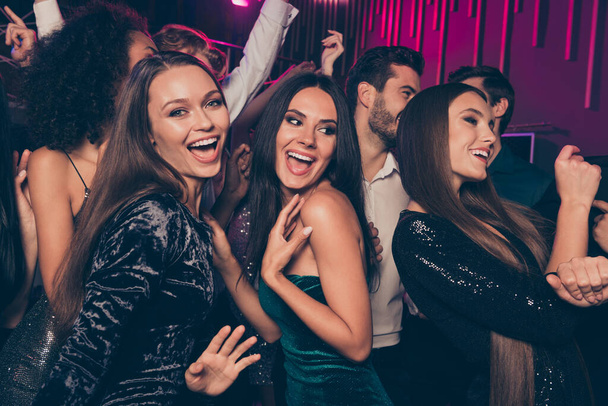 Photo of cheerful laughing happy beautiful girls wearing fashionable dress dancing at party in night club together celebrating new year with friends - Zdjęcie, obraz