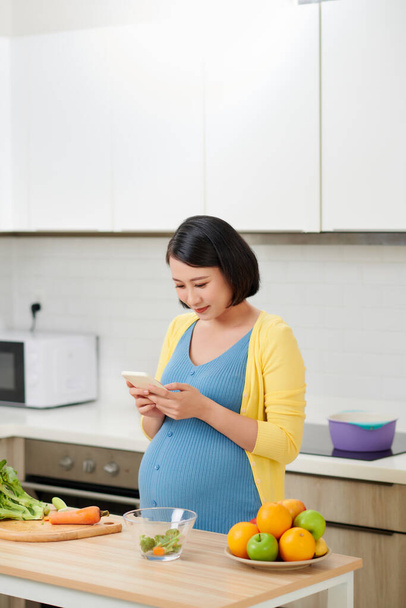 szczęśliwy w ciąży kobieta za pomocą nagrywarki głosowej na smartfonie  - Zdjęcie, obraz
