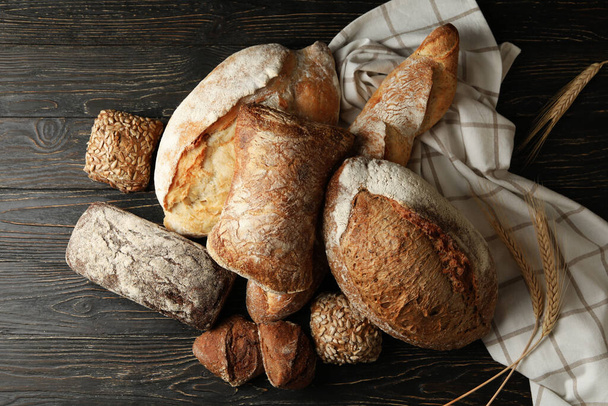 Different fresh bakery products on wooden background - Fotó, kép