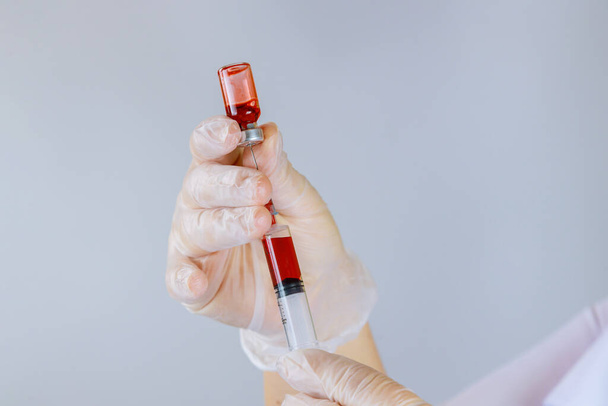 Female hands nurse medical syringes dilution blood bottle at workplace - Photo, Image
