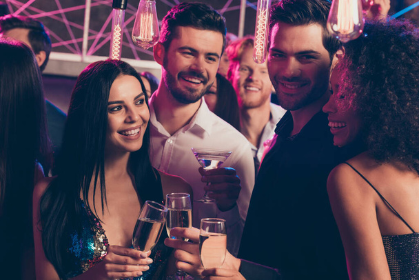 Retrato fotográfico de gente atractiva bebiendo juntos champán en el club nocturno hablando sosteniendo sabrosa bebida - Foto, Imagen