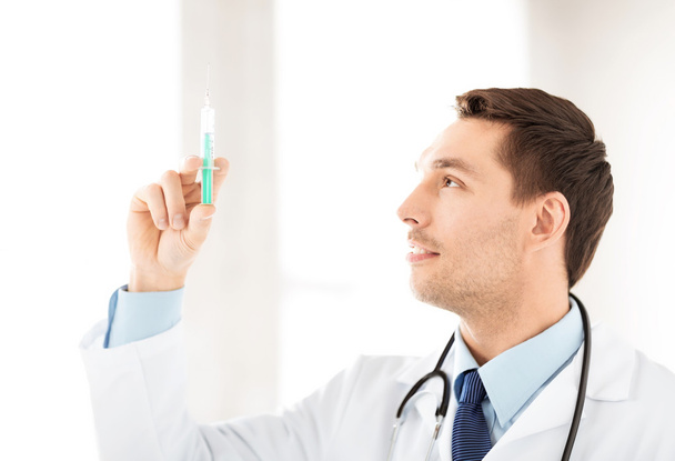 Male doctor holding syringe with injection - Foto, Imagen