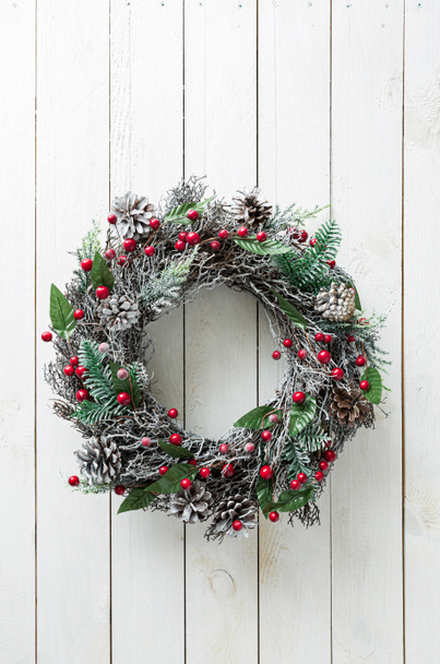 Christmas wreath on white wooden background. Winter holiday - traditional, rustic home decoration. Layout with free copy (text) space. - Foto, imagen