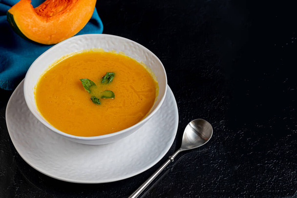 Fresh pumpkin cream soup with sour cream. Autumn lunch concept. On a wooden background. A dietary, healthy dish. Copy space. - Photo, Image