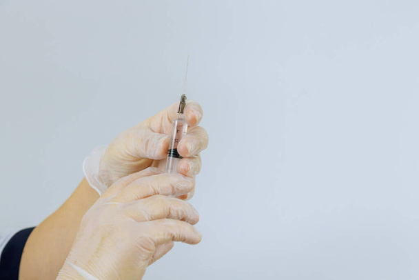 Doctor hands in medical gloves holding with medical injection syringe - Photo, Image
