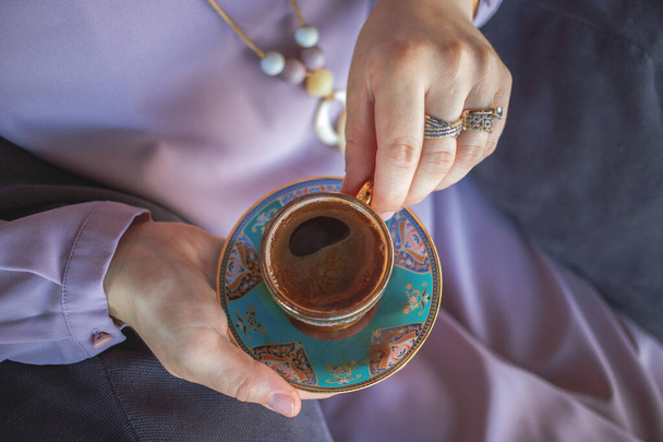 Мусульманские женщины держат в руках чашку традиционного турецкого кофе - Фото, изображение