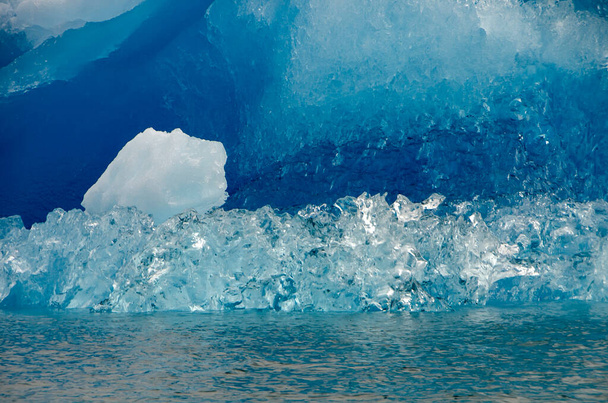 Transparant ijs van een ijsberg met blauw ijs op de achtergrond - Foto, afbeelding