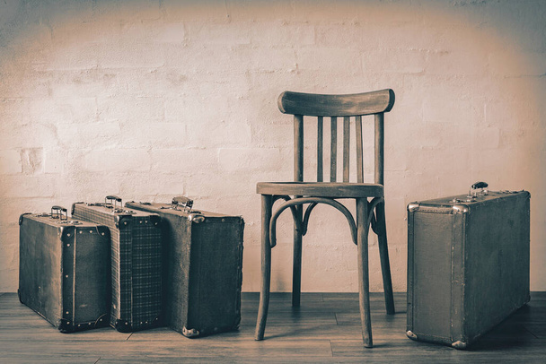 Vieille valise et chaise en bois debout dans une pièce vide.Photo teintée - Photo, image