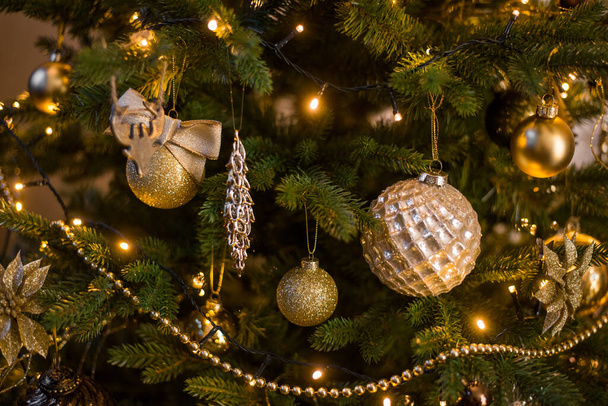 Juguetes de Navidad en oro en los árboles de Navidad t - Foto, Imagen