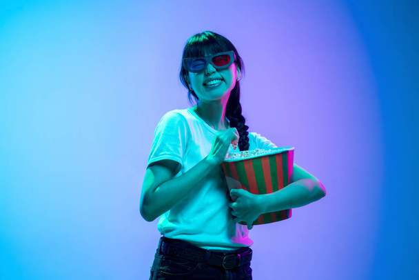 Jeune asiatique womans portrait sur dégradé bleu-violet studio fond en néon lumière - Photo, image
