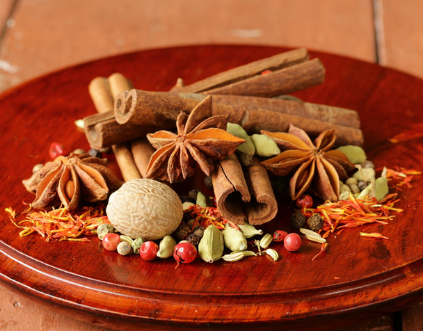 Various spices (nutmeg, cinnamon, star anise, saffron, pepper, cardamom, fennel) - Photo, Image