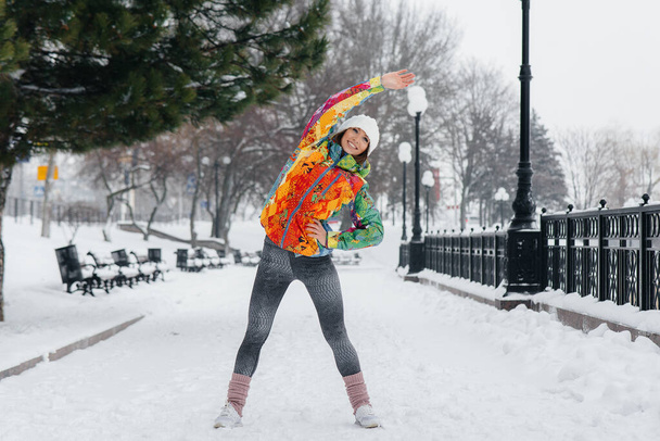 A young athletic girl does sports on a frosty and snowy day. Fitness, running - Фото, зображення